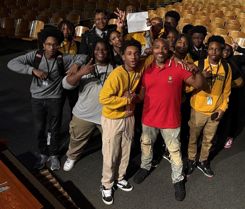 Page Kennedy with students in auditorium